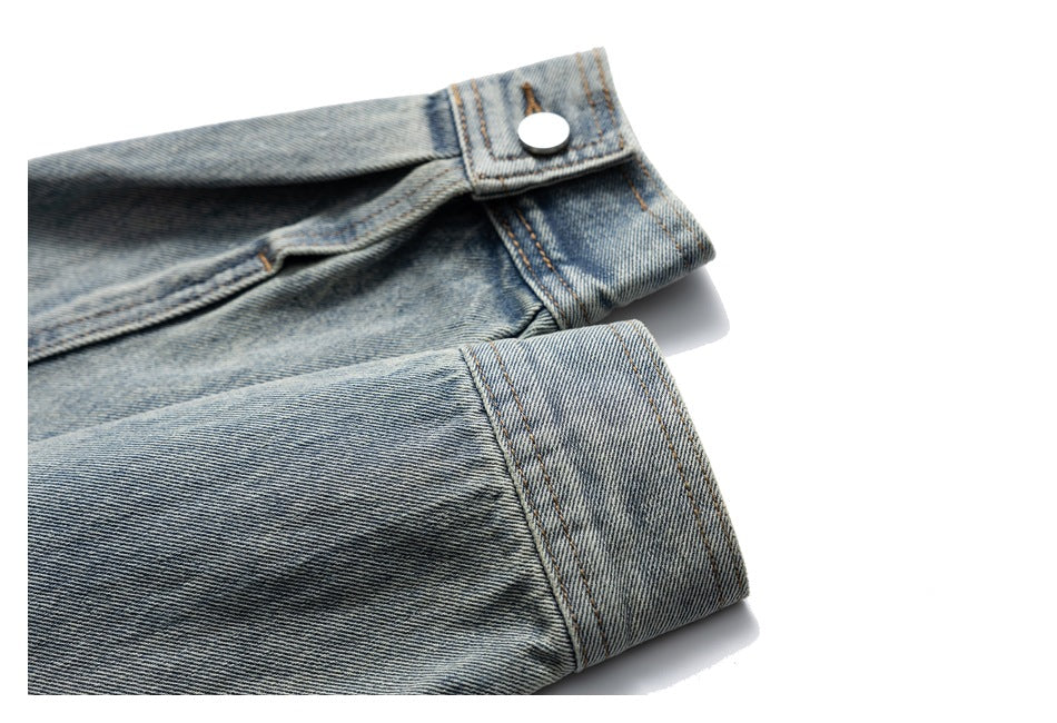 Close-up of light blue washed denim jeans showing the waistband button, seams, and folded hem.