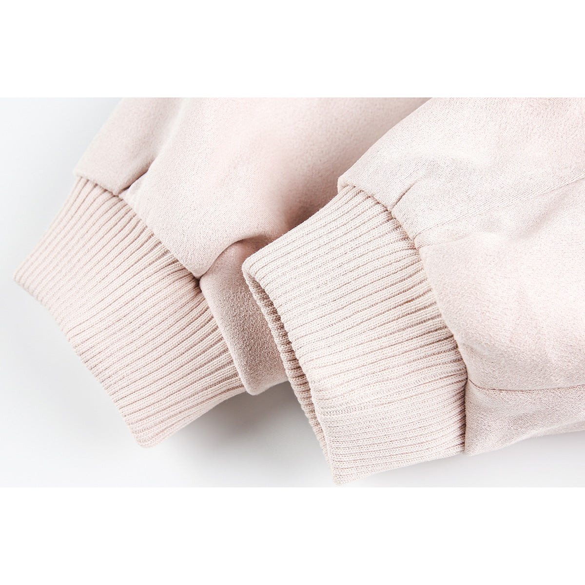 Close-up of pale blush jacket sleeves with wide rib-knit cuffs.