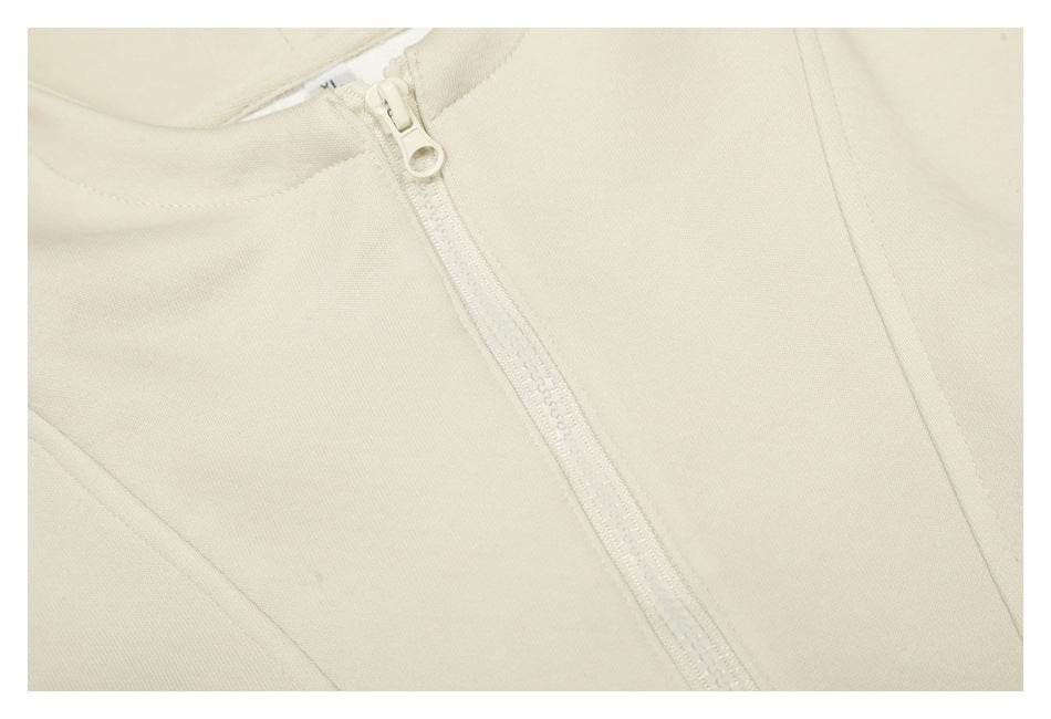 Tight close-up of the cream hoodie’s zipper and surrounding fabric.
