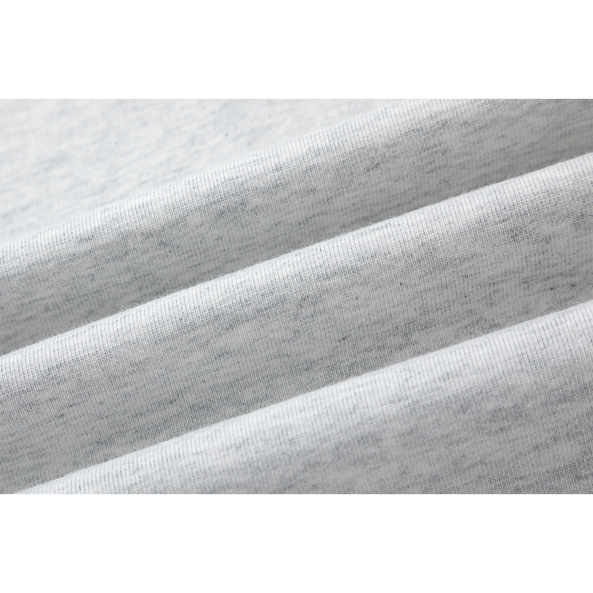 Close-up of light gray heathered T-shirt fabric arranged in soft folds.