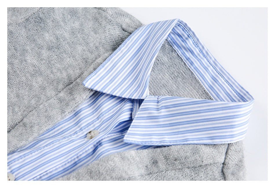 Close-up of a gray knit top with a blue-and-white striped pointed collar and button placket.