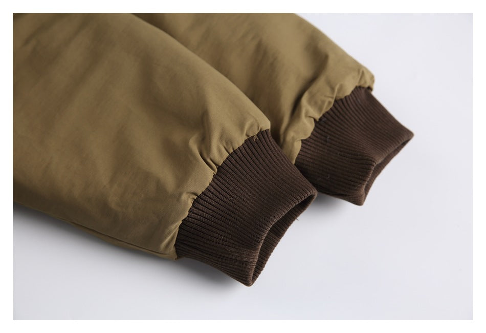 Close-up of khaki jacket sleeves finished with dark brown ribbed cuffs.