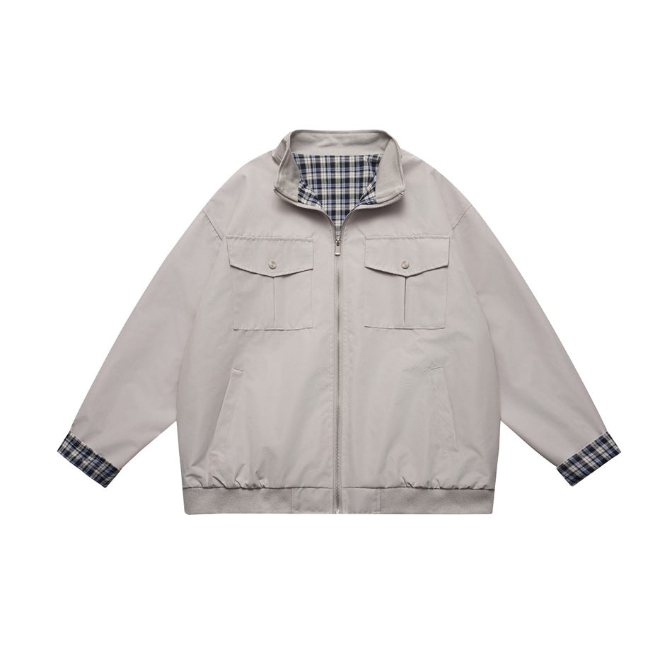 Light gray zip-front jacket with stand collar, flap chest pockets and blue plaid lining at collar and cuffs