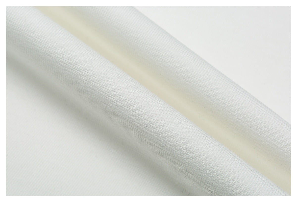 Close-up of white fabric folded to show its knit texture.