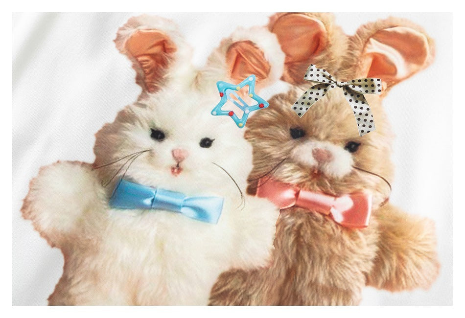 Close-up of the sweatshirt's graphic showing two fluffy animals with colorful bows and hair clips.