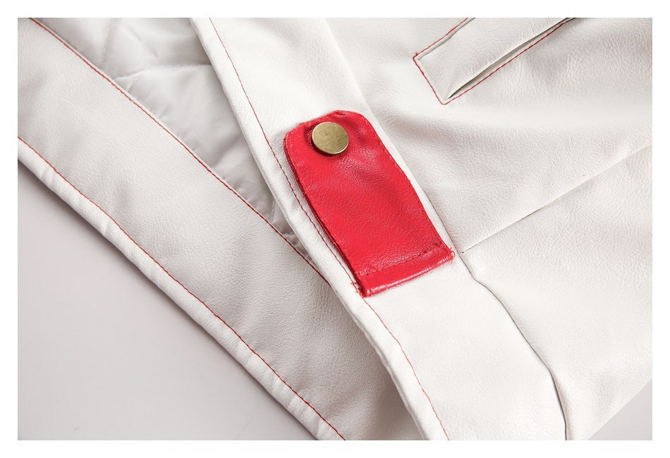 Close-up of a white jacket with red topstitching, a bright red snap tab, and a gold-tone button.