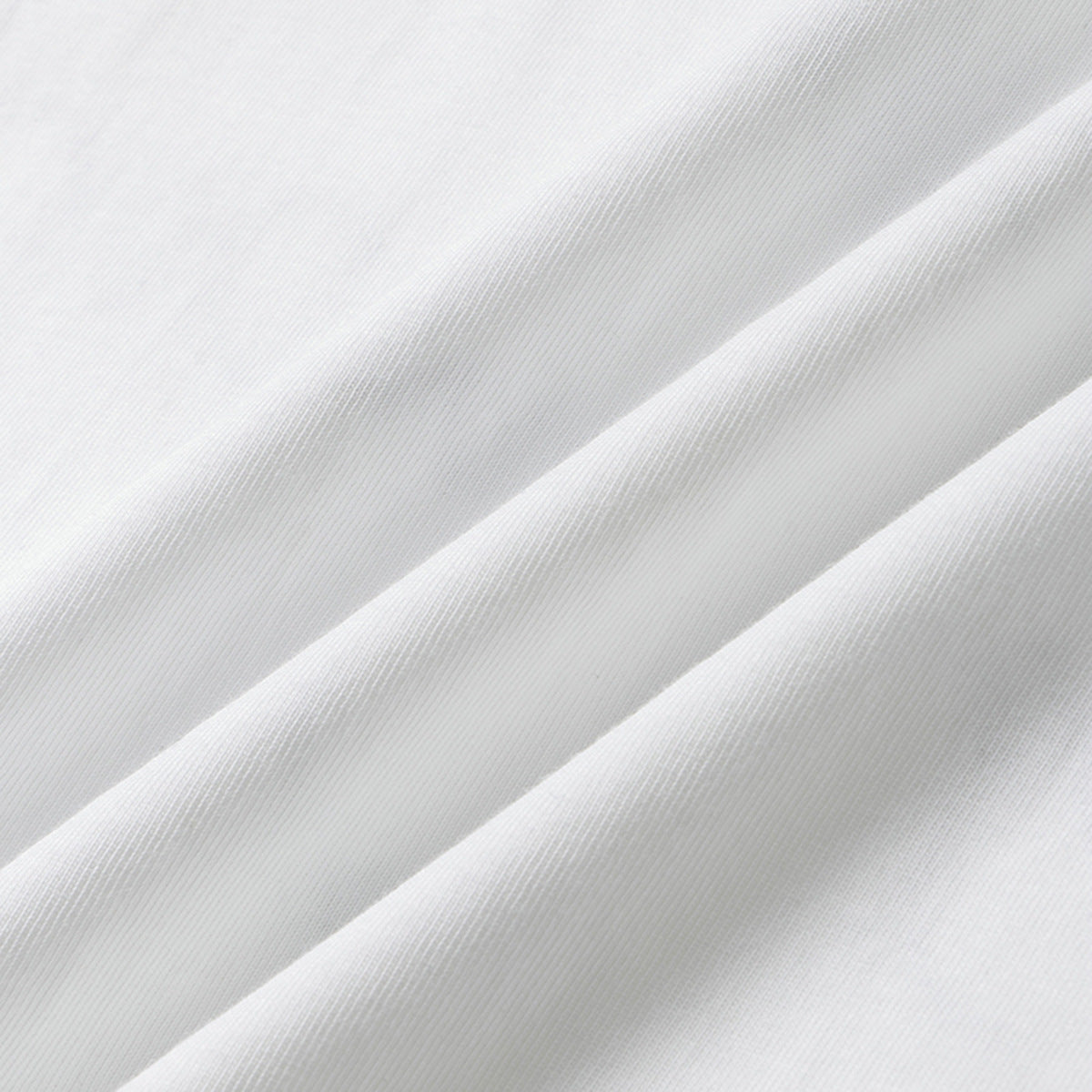 Close-up of white knit fabric arranged in soft diagonal folds.