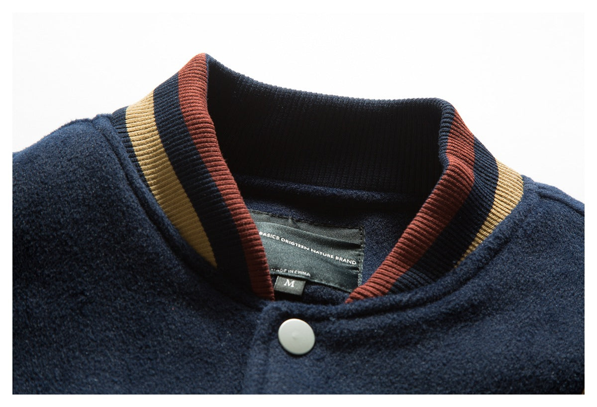 Close-up of a navy jacket collar with rust and tan striped ribbing, a snap, and an inner label.
