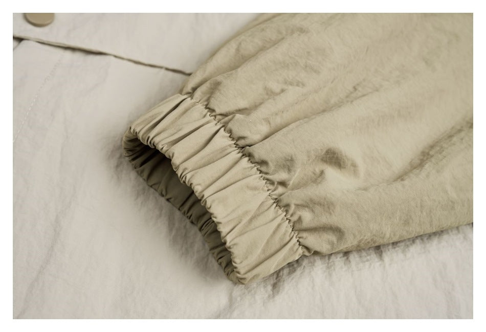 Close-up of an ivory garment sleeve with a gathered elastic cuff.