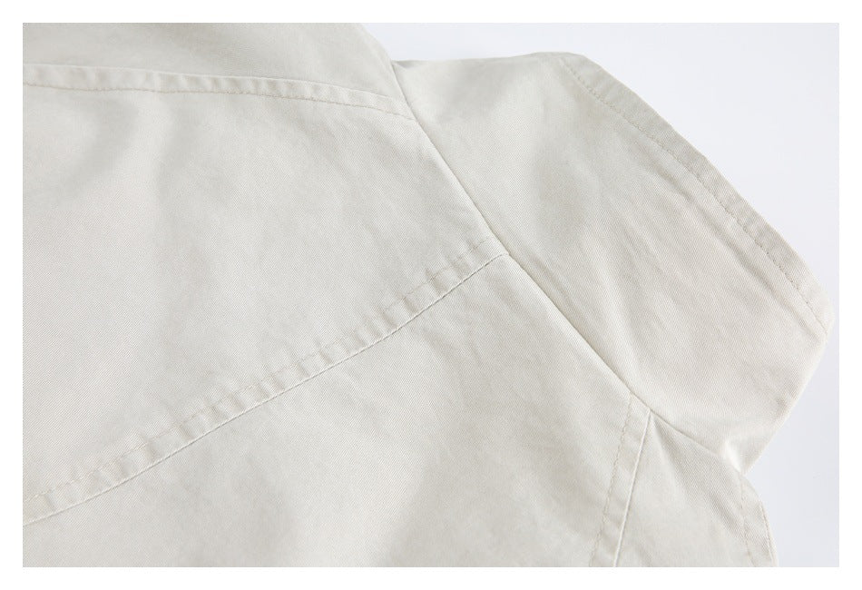 Close-up of cream fabric panels and curved seams on the garment.