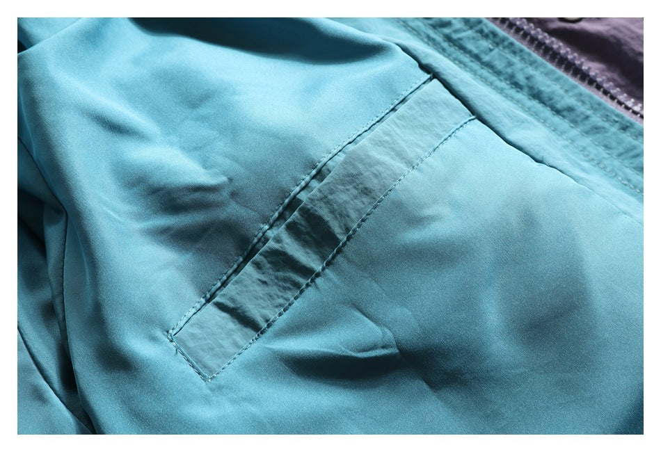 Close-up of turquoise garment fabric with a diagonal stitched panel and seam.