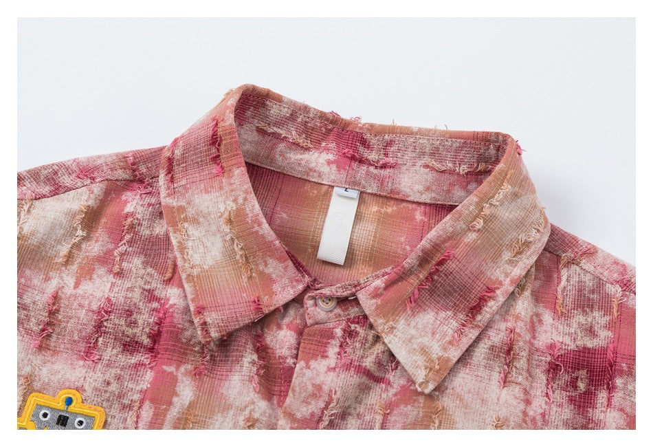 Close-up of a pointed collar and upper placket on a pink, cream and tan distressed plaid shirt.