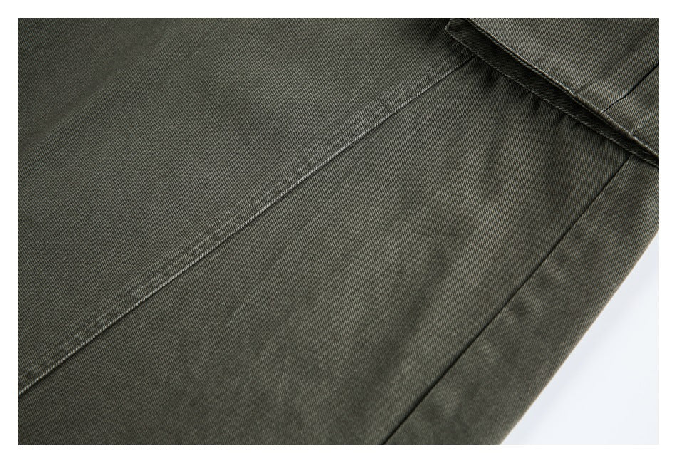 Close-up of olive-gray trouser panels and diagonal seam stitching.