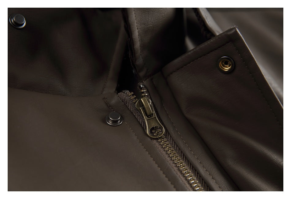 Close-up of a brass-tone front zipper and snap fasteners on a dark brown jacket.