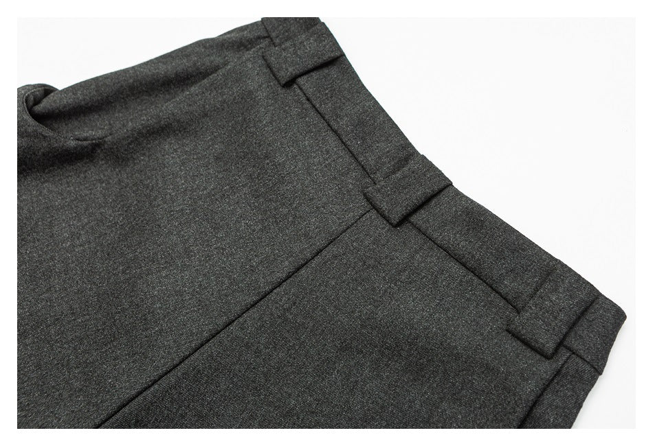 Close-up of charcoal trousers showing the waistband, belt loops and side seam.