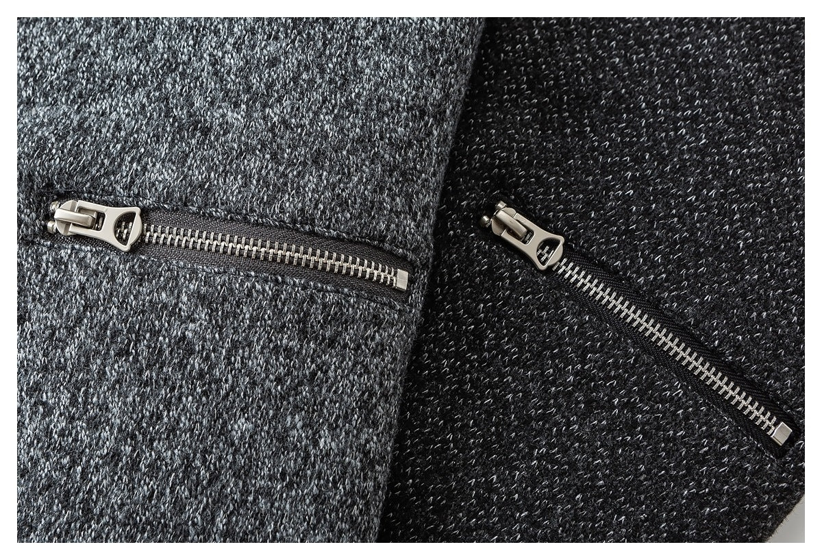 Close-up of metal zippers on gray and black marled fabric.