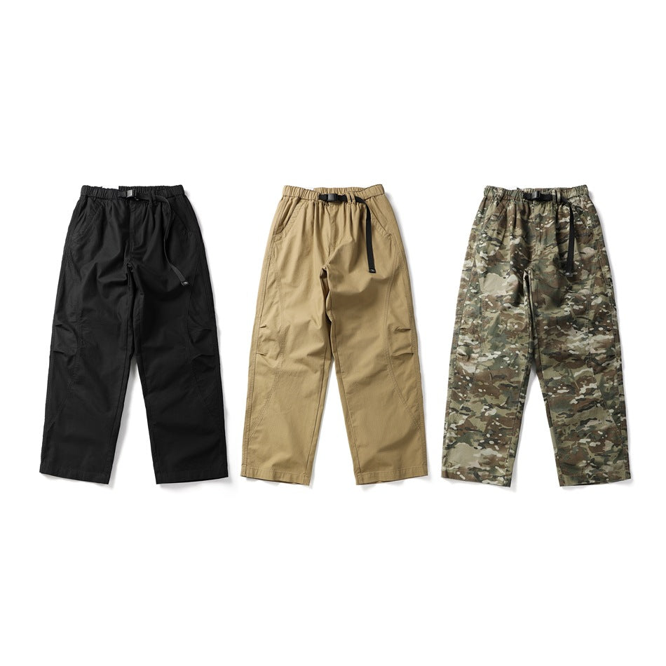 Three pairs of loose trousers shown from the front in black, tan, and olive camouflage.
