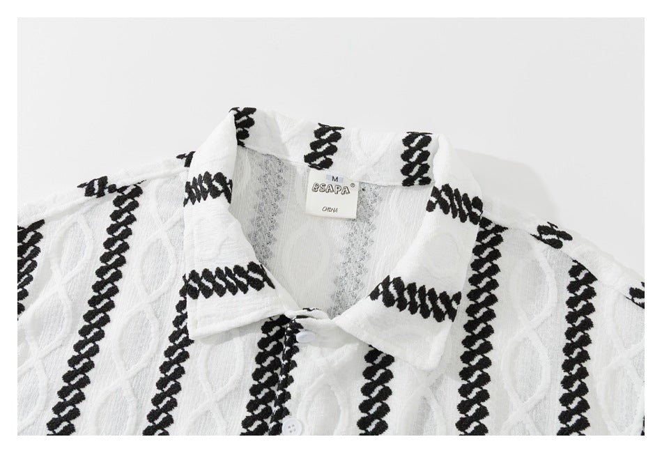Close-up of a white shirt's collar, black striped pattern, buttons, and neck label.
