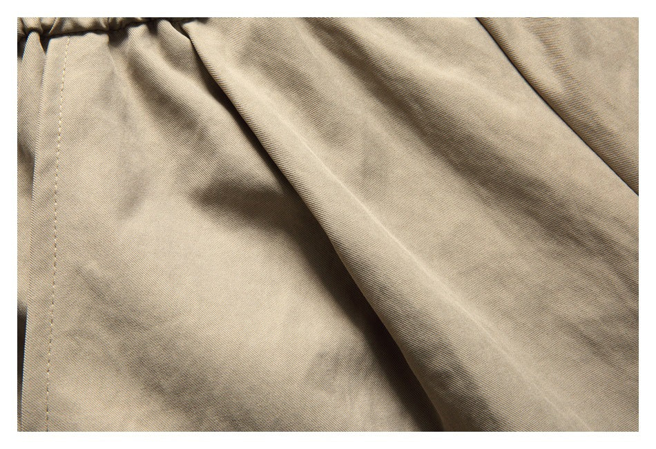 Close-up of khaki shorts fabric and a stitched seam.