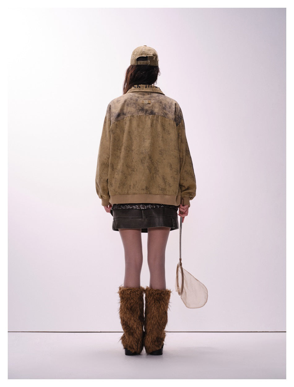 Model wearing the mottled tan-brown jacket, shown from the back with a yoke seam and small upper-back patch.