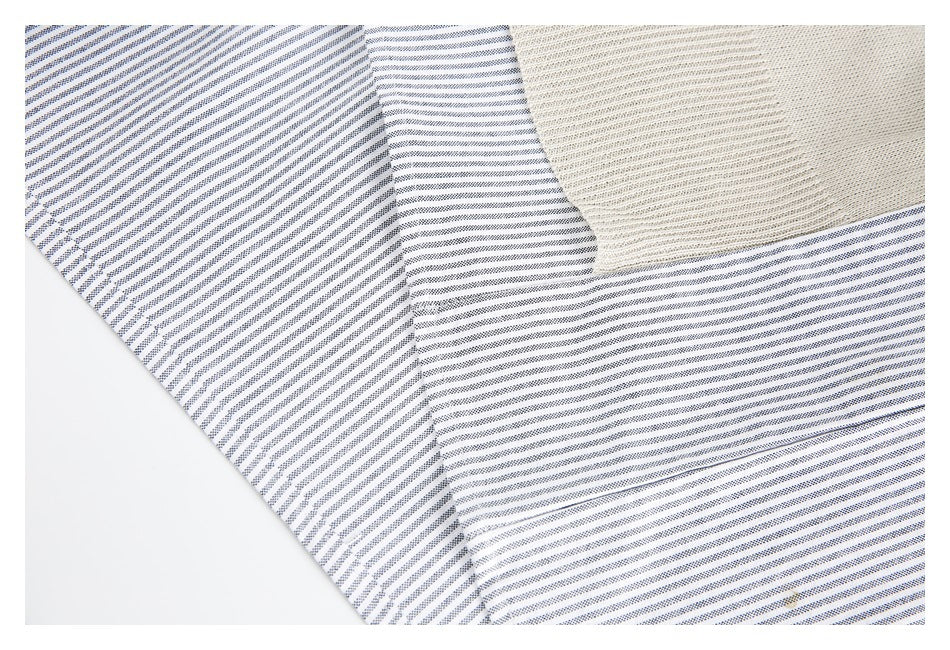 Close-up of white fabric with navy stripes beside a cream textured panel.