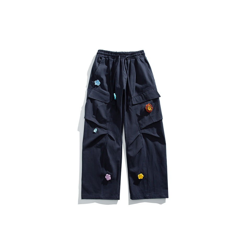 Navy wide-leg cargo pants front view with flap pockets and colorful crocheted flower appliqués
