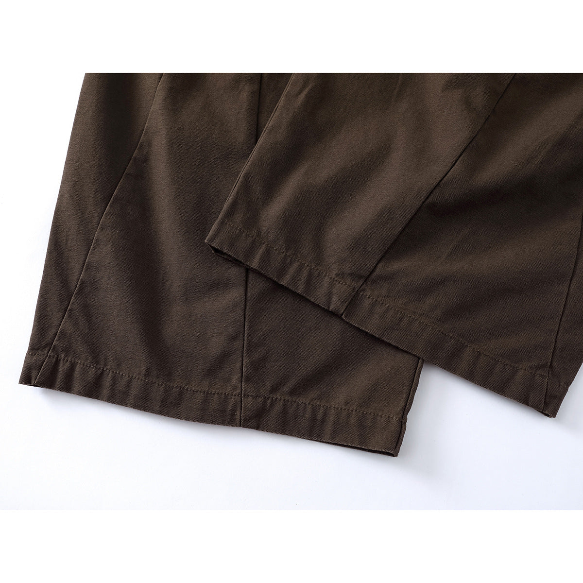 Close-up of dark brown pants showing the wide-leg hems and stitching.