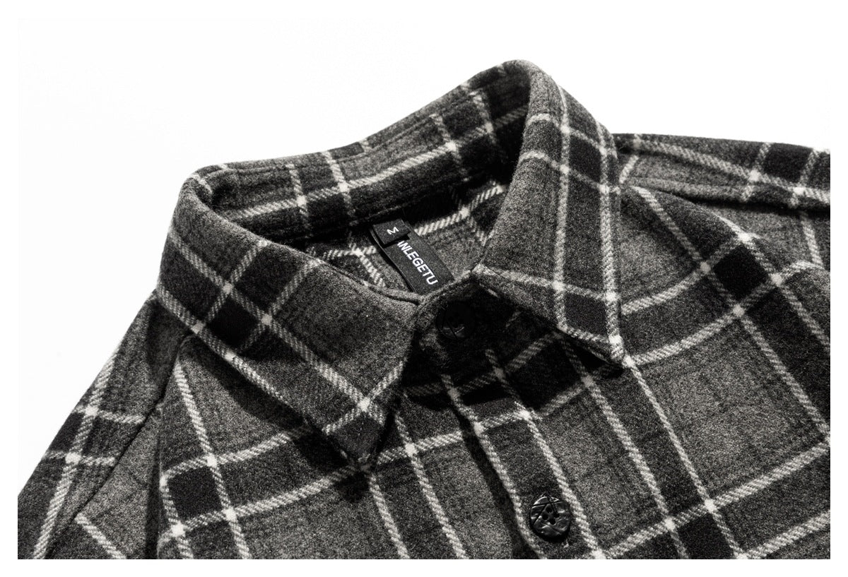 Close-up of the charcoal gray plaid shirt's collar and black front buttons.