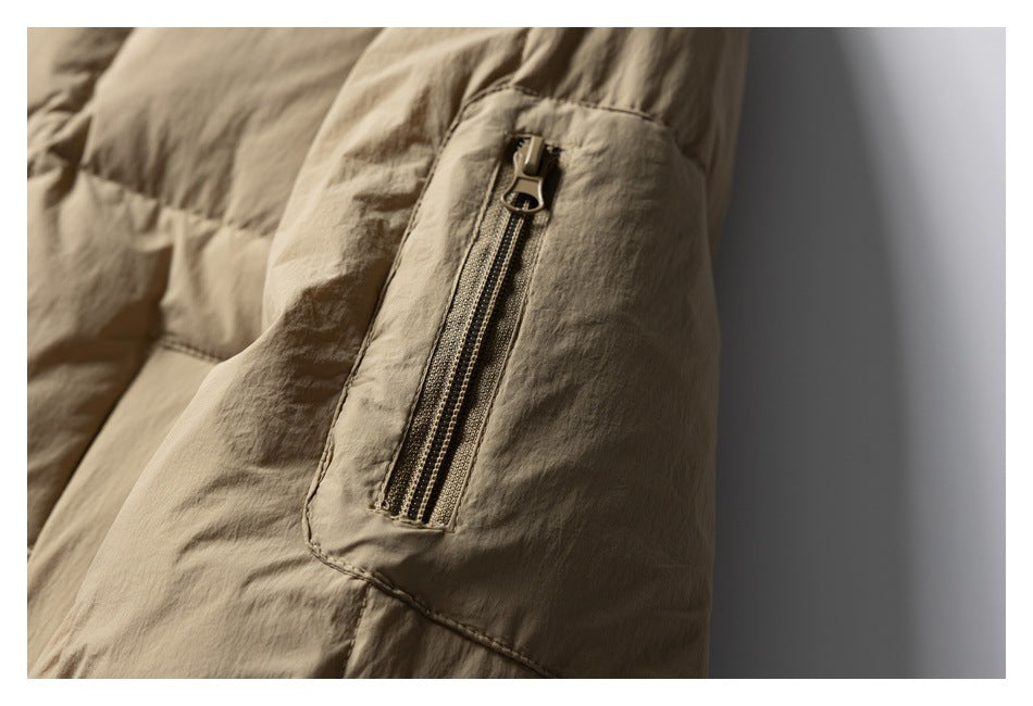 Close-up of a beige jacket sleeve with a narrow zippered pocket.