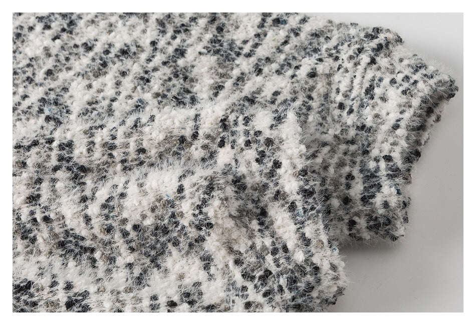 Close-up of the black-and-white fuzzy garment's folded edge and textured surface.