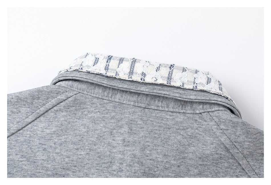 Back collar detail of a gray top, showing a white and navy floral lace insert.