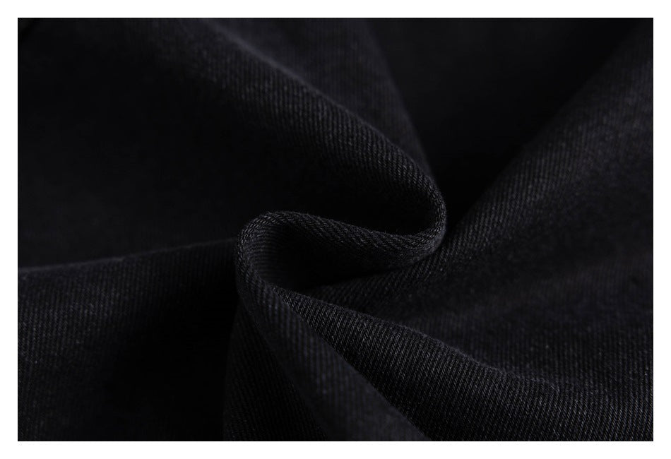 Macro view of black twill fabric gathered into a fold.