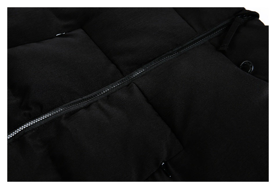 Close-up of a black padded jacket's front zipper across the quilted panels.