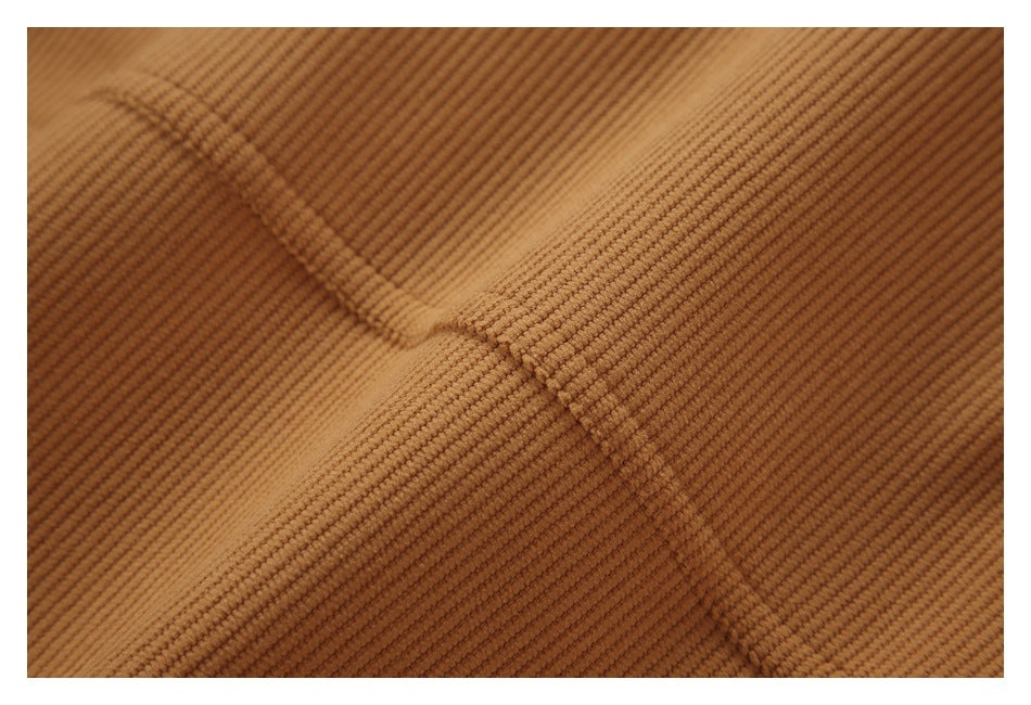 Macro view of a seam and raised ribs on caramel-brown fabric.