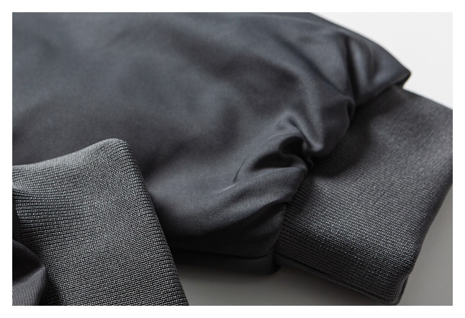 Close-up of a dark charcoal garment cuff with ribbed knit trim.