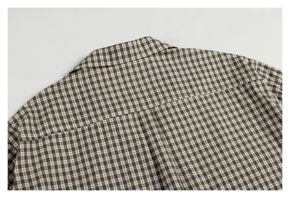 Close-up of the upper back of a gray-green check shirt, showing its collar and shoulder yoke.
