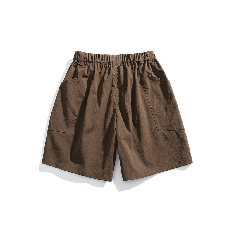 Brown shorts with an elastic waistband and large patch pockets on both sides, shown against white.