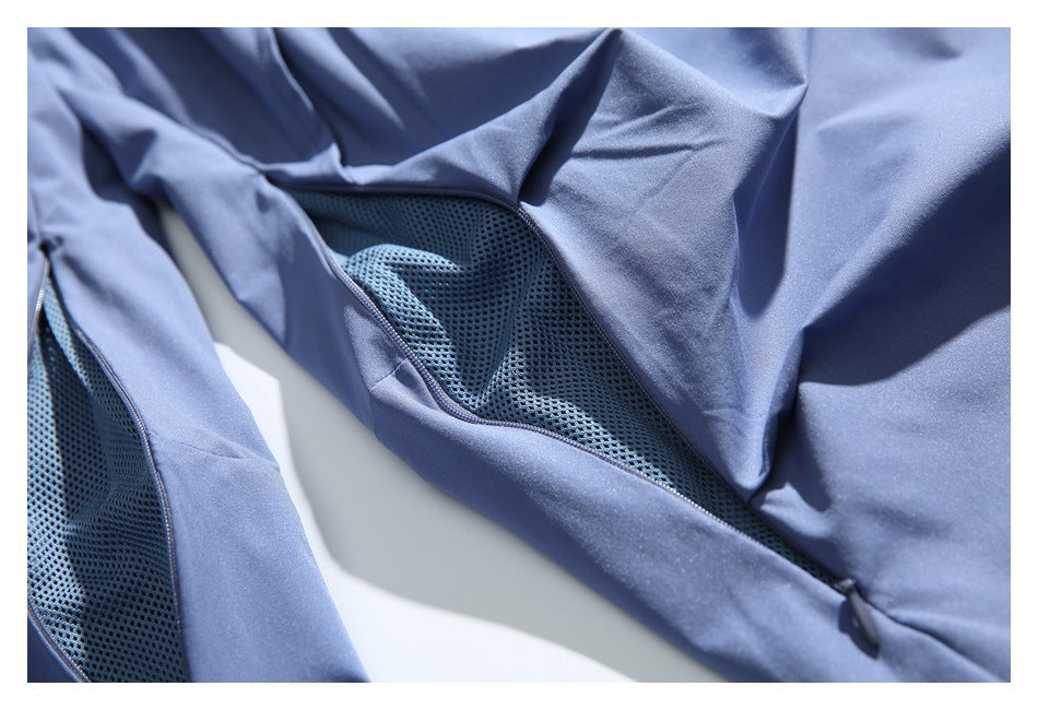 Close-up of blue shorts showing a dark mesh ventilation panel and smooth fabric.
