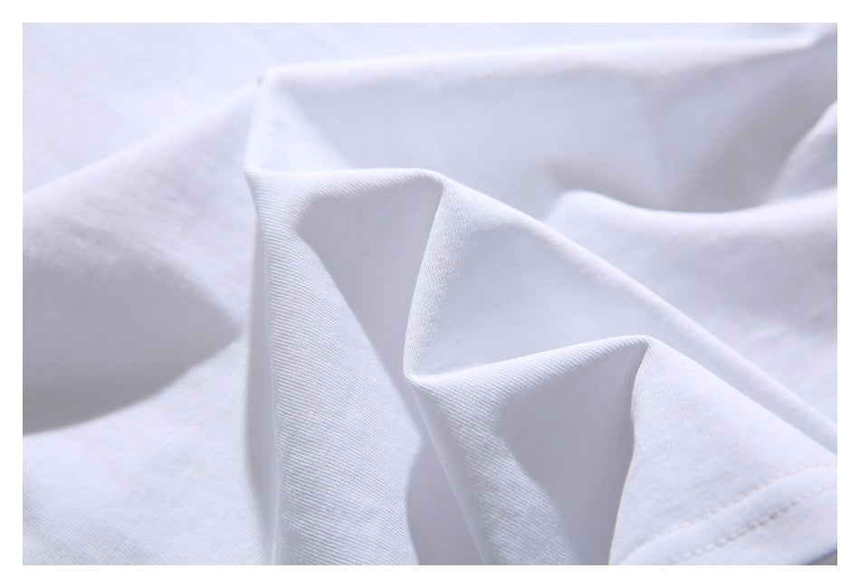 Close-up of white shirt fabric arranged in soft folds, showing its surface texture.