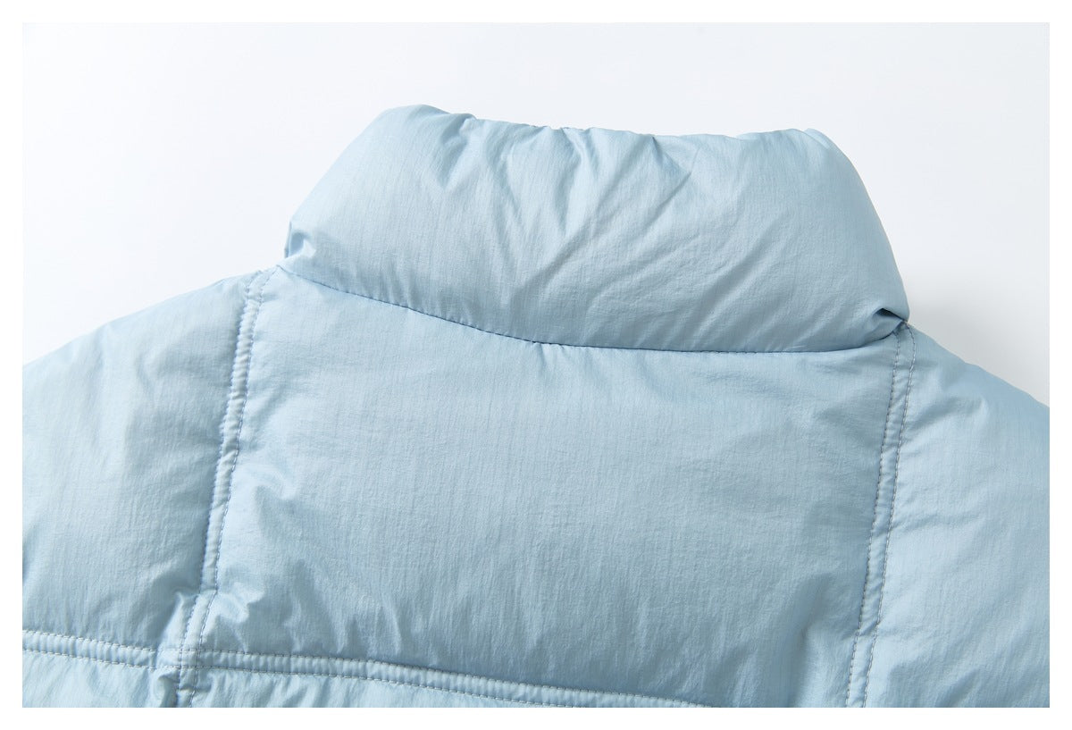 Close-up of a light blue padded jacket showing its raised collar and stitched panels.