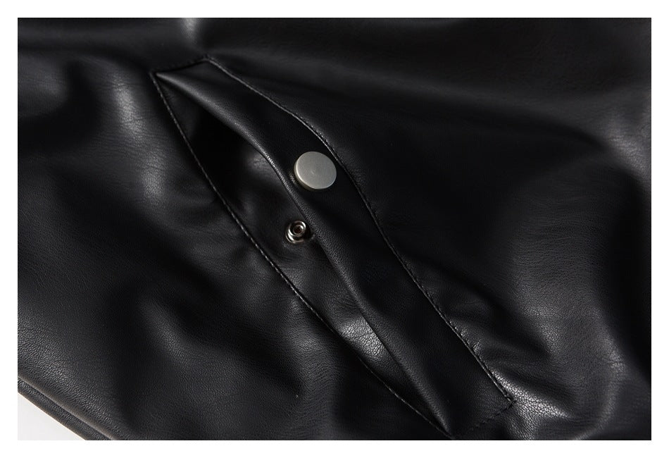 Close-up of a black jacket flap with a round metal snap fastener.