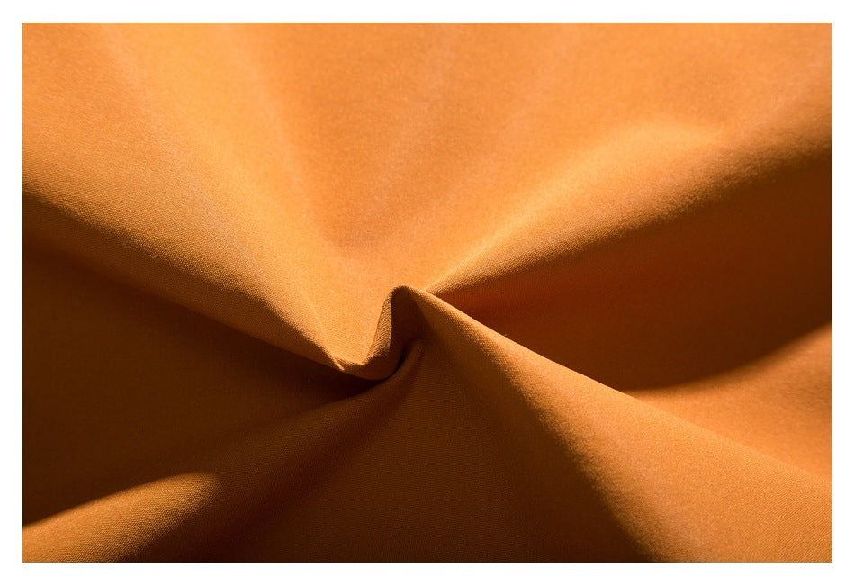 Extreme close-up of the orange jacket fabric showing its surface and drape.