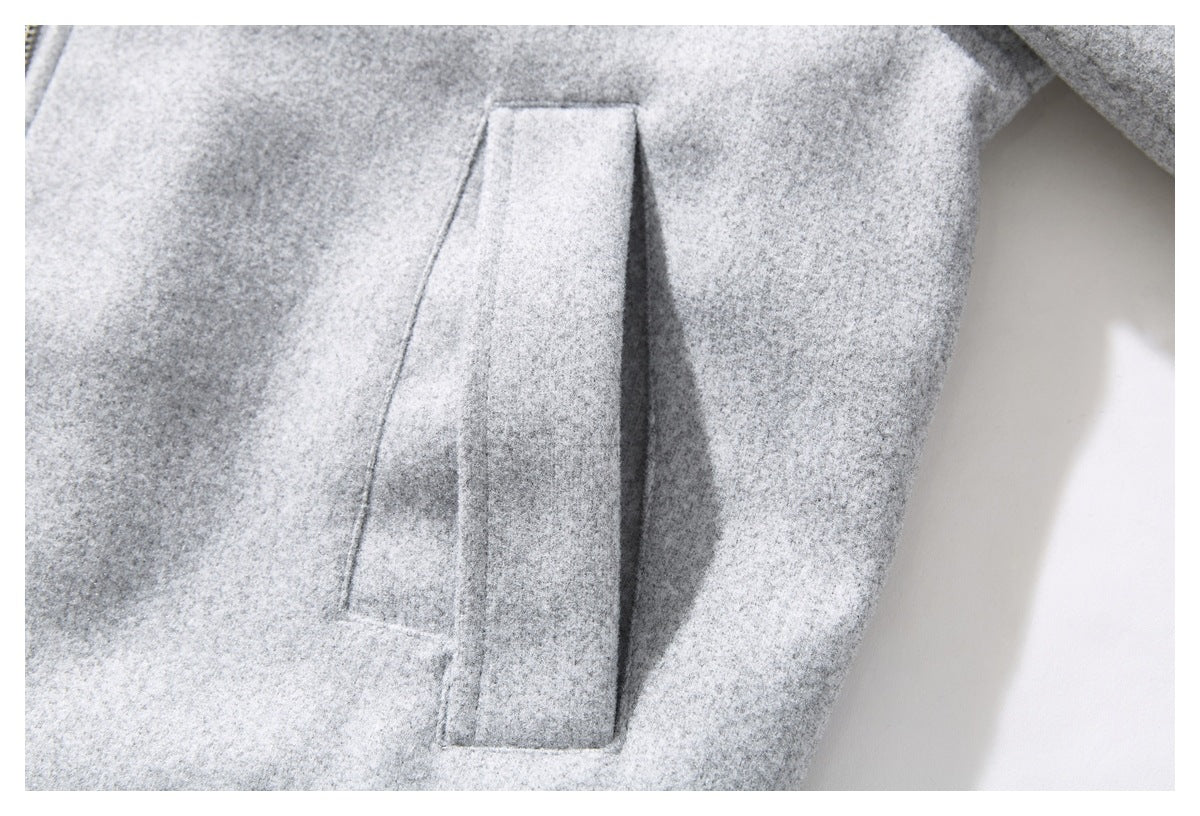 Close-up of a vertical welt pocket on a light gray coat.