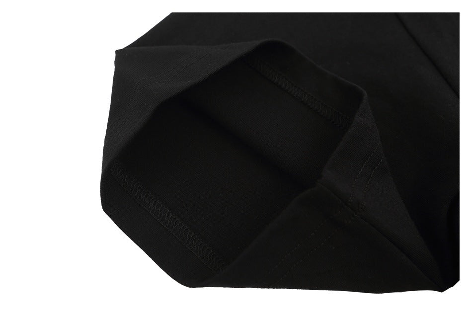 Close-up of folded black T-shirt fabric and visible overlock stitching.