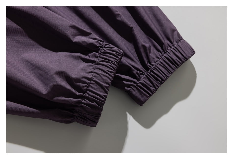Close-up of two gathered elastic cuffs on a dark plum garment.