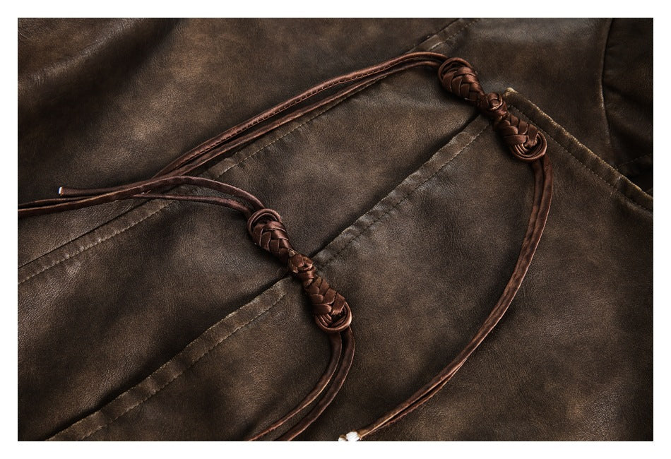 Close-up of a brown jacket's braided ties and decorative knots against stitched panels.
