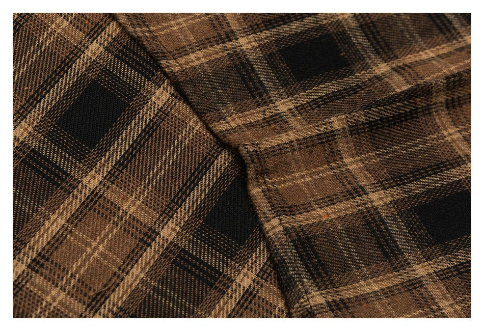 Close-up of the brown and black plaid shirt fabric and intersecting seams.