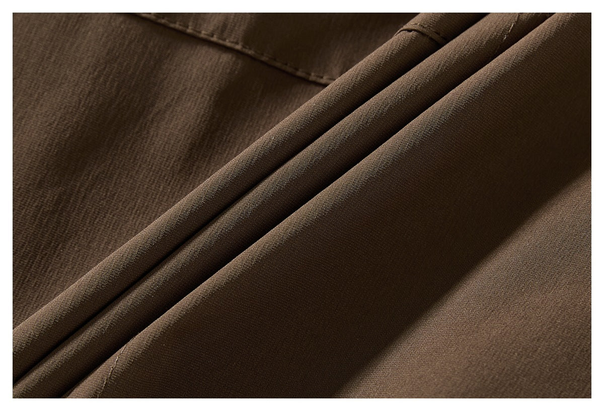 Macro view of brown jacket fabric folded to show its surface and stitching.
