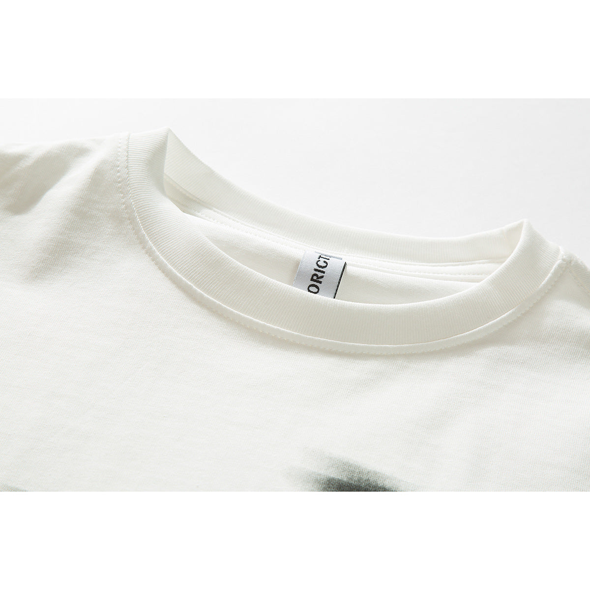 Close-up of an off-white T-shirt's ribbed crew neck and inner label.