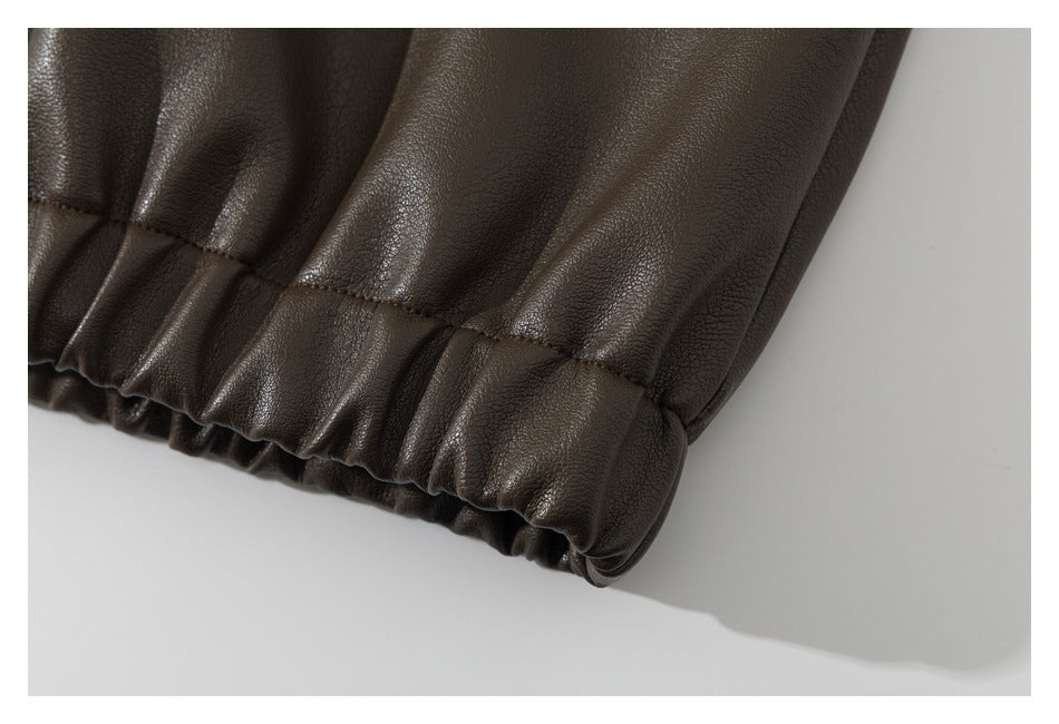 Close-up of a dark brown garment hem with gathered elastic and visible stitching.